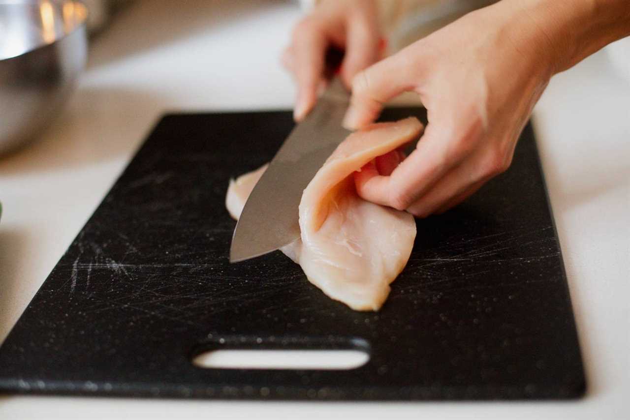 Slicing chicken in half lengthwise.