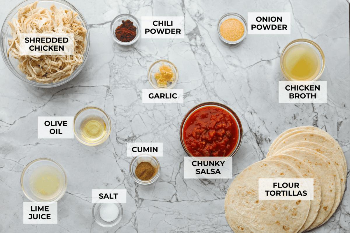 Overhead shot of labeled shredded chicken tacos ingredients. 