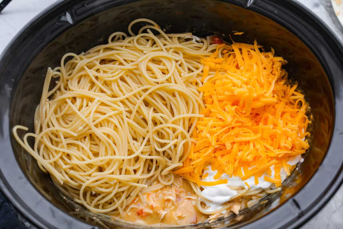 Cooked spaghetti noodles, cheese and sour cream added to the chicken and sauce mixture. 