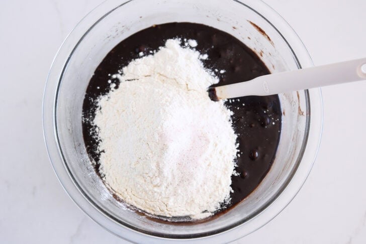 Glass bowl with melted chocolate batter, flour and salt.