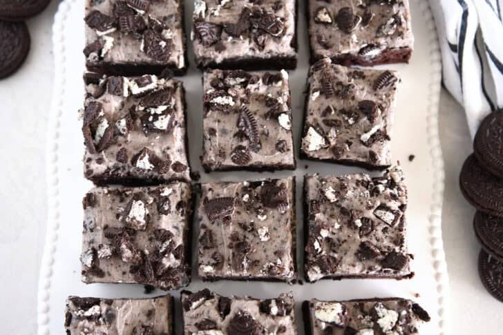 Nine squares of cookies and cream oreo brownies on white tray.