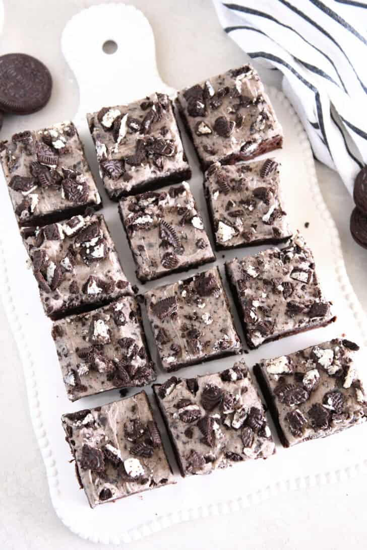 Nine squares of cookies and cream oreo brownies on white tray.