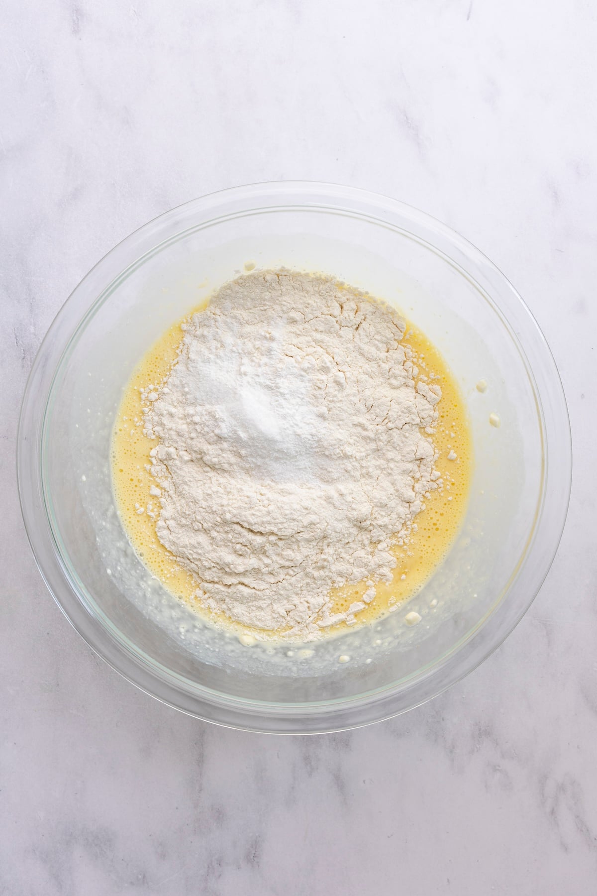 medium bowl with flour, baking powder, and salt added to cottage cheese/milk mixture