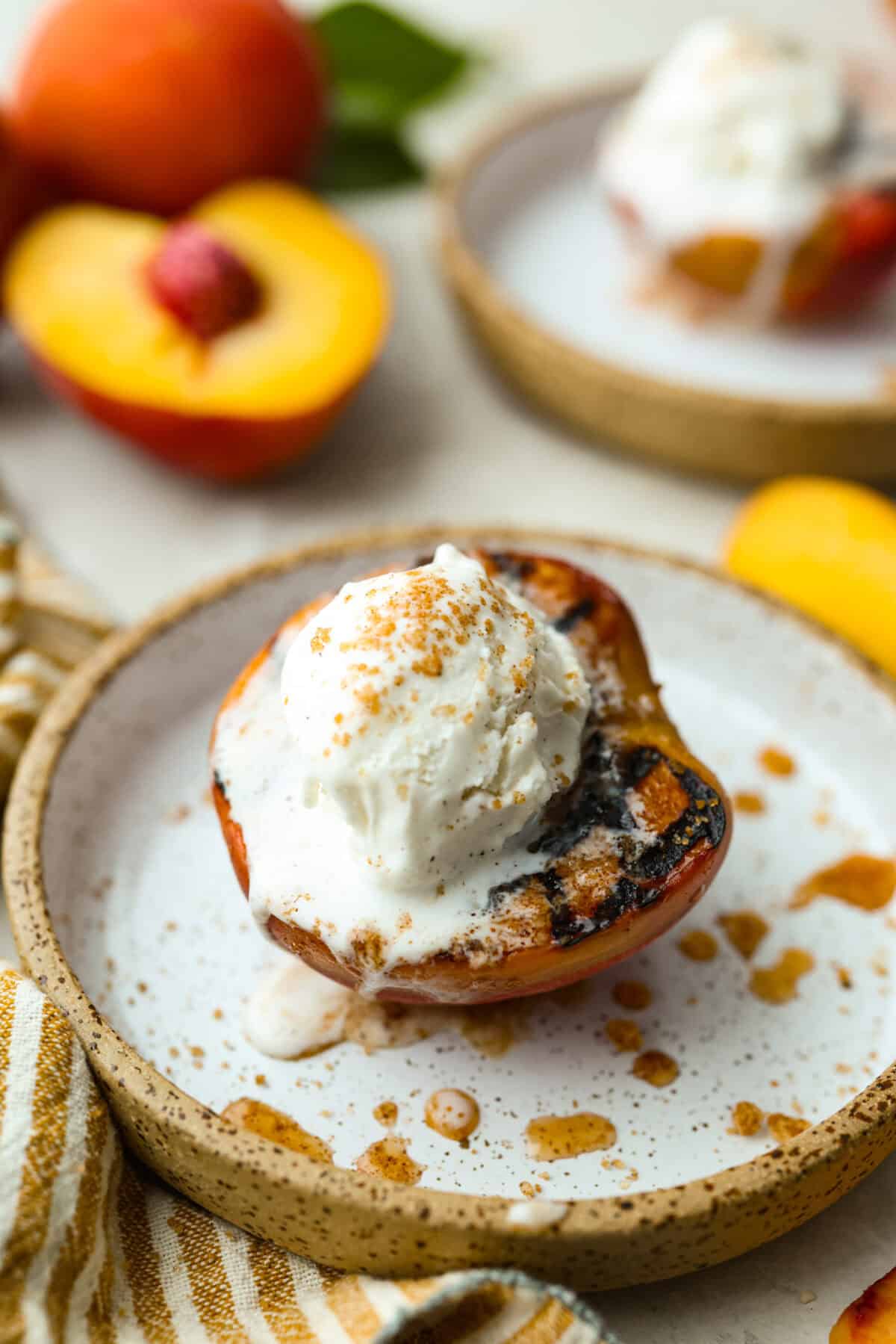 Grilled peaches topped with ice cream.