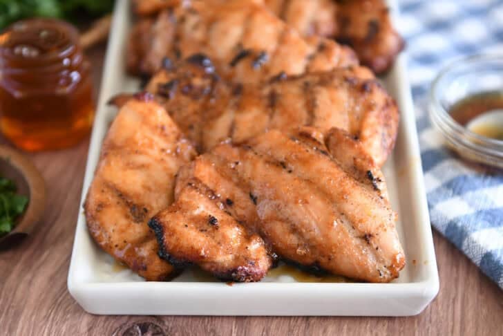 White tray with five or six pieces of grilled honey garlic chicken.