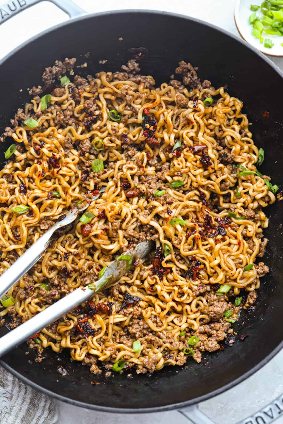 Skillet filled with chili crisp beef ramen. 