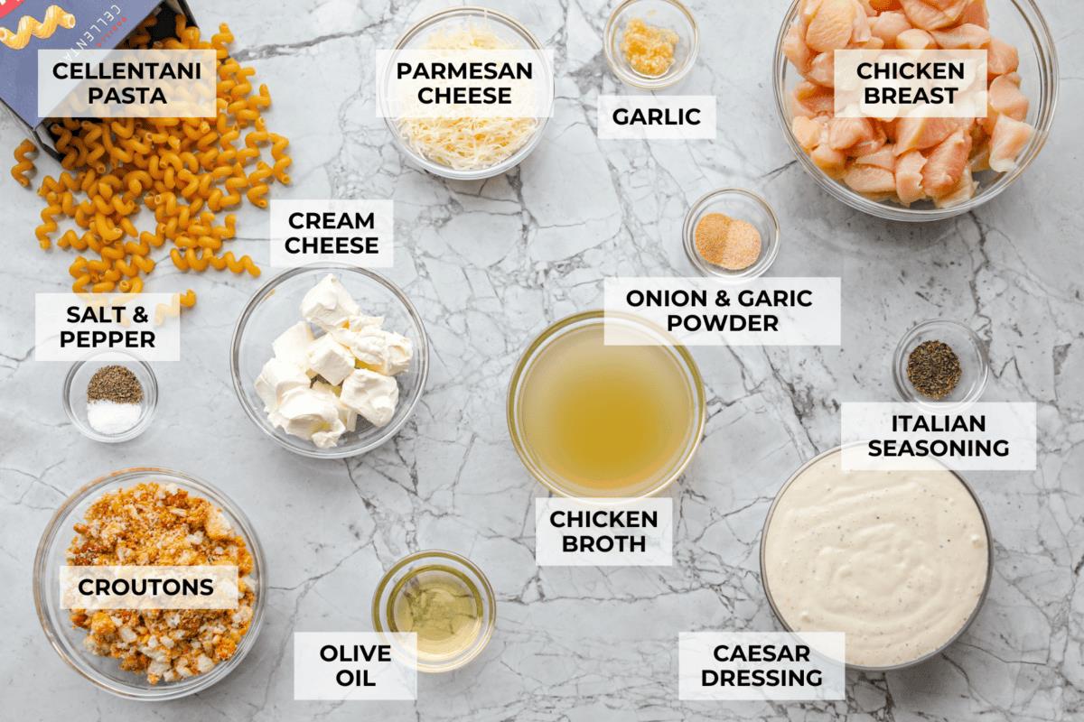 Overhead shot of labeled chicken caesar pasta ingredients. 