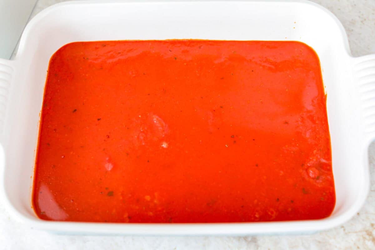 Marinara sauce poured into the bottom of the baking dish. 