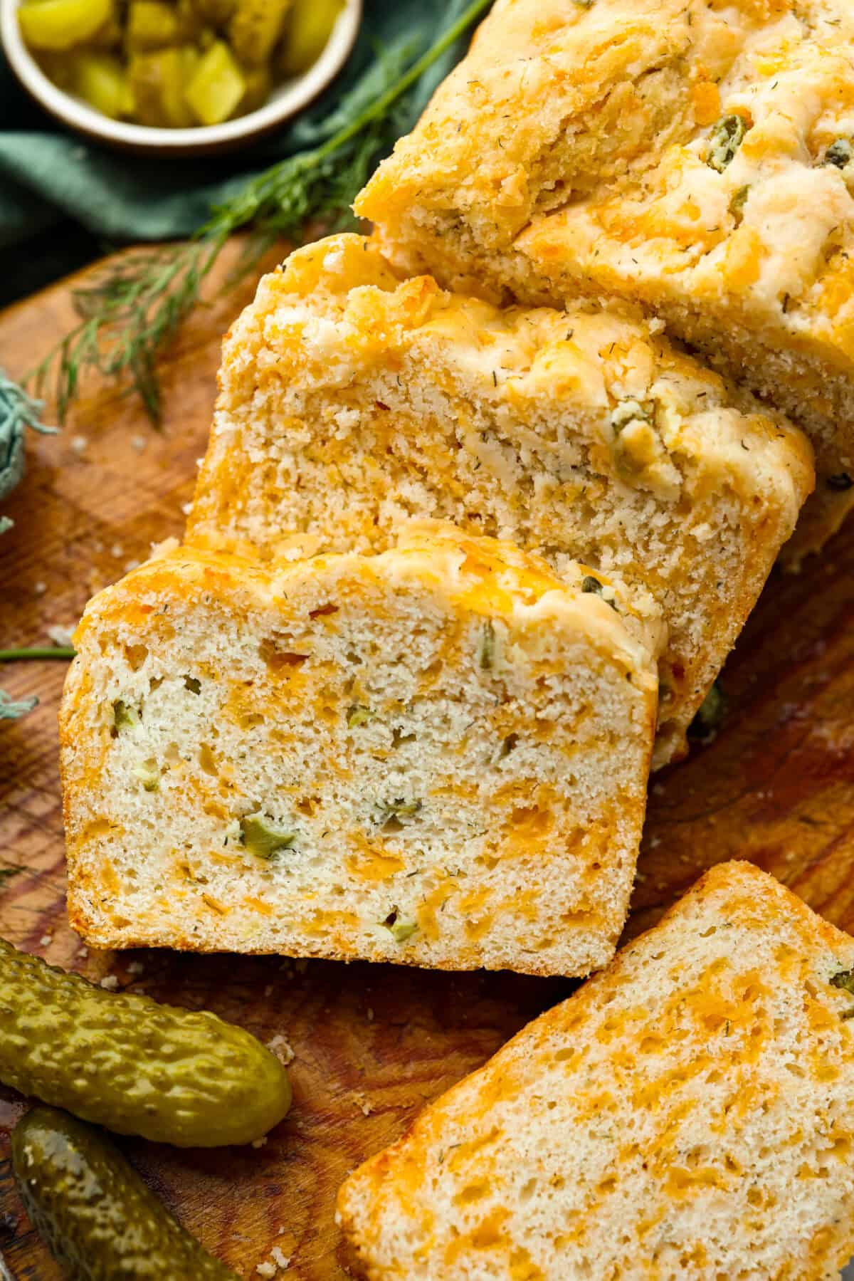Overhead shot of dill pickle bread on a cutting board with some slices cut.