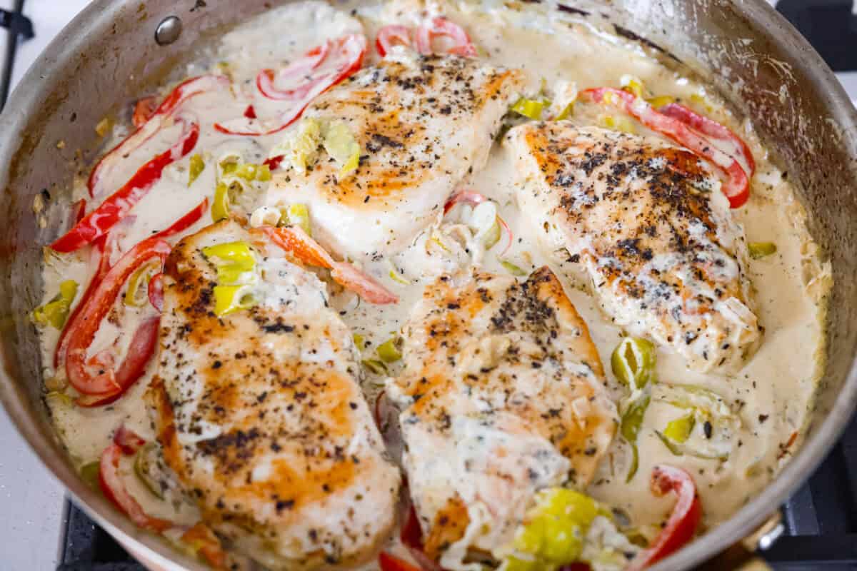 Cooked chicken breasts added back to the skillet to cook in the creamy pepperoncini chicken sauce. 