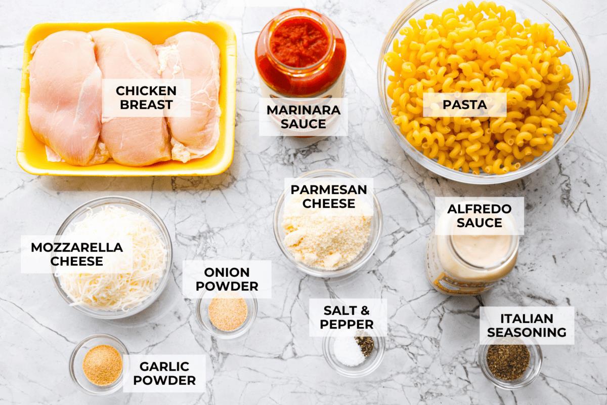 Overhead shot of labeled crockpot creamy chicken pasta ingredients. 