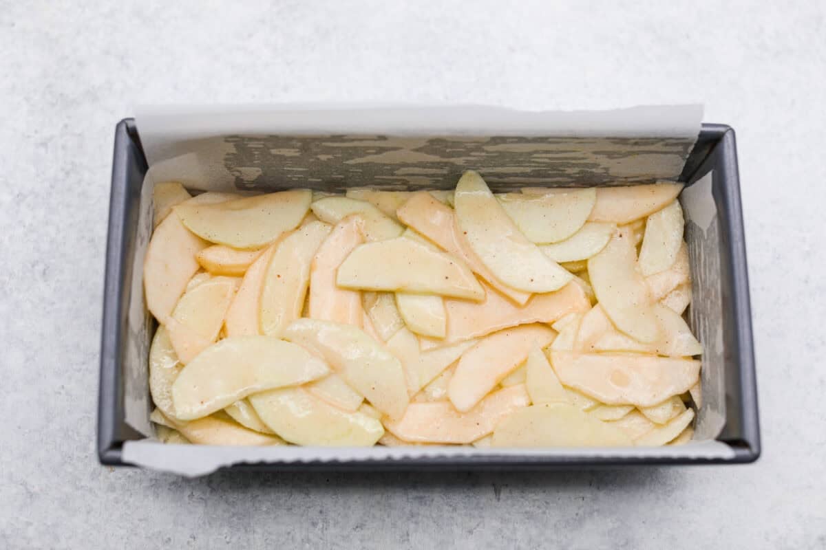 Apple and batter mixture added to the loaf pan. 