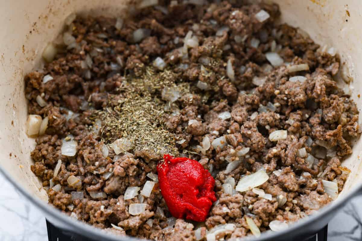 Seasonings and tomato pasta added to the ground beef mixture. 