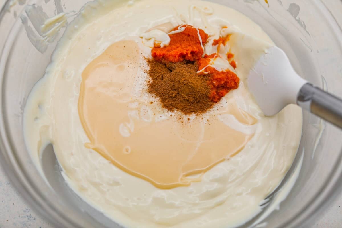 Pumpkin puree, sweetened condensed milk, and pumpkin pie spice added to the melted white chocolate. 