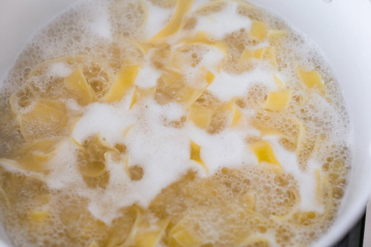 Pappardelle pasta cooking in boiling water. 