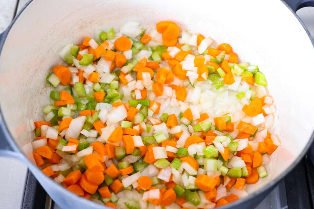 Celery, onions, and carrots cooking in the olive oil in the pot. 