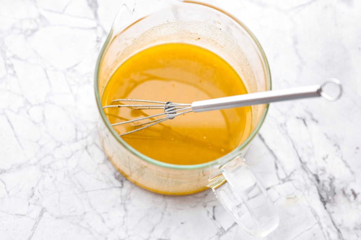 Dressing ingredients added to a container and whisked together. 
