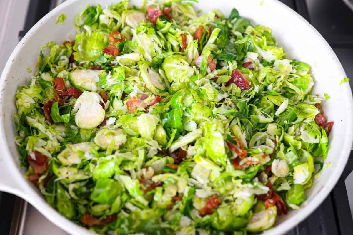 Brussels sprouts, bacon bits, and almonds cooking in the same skillet. 