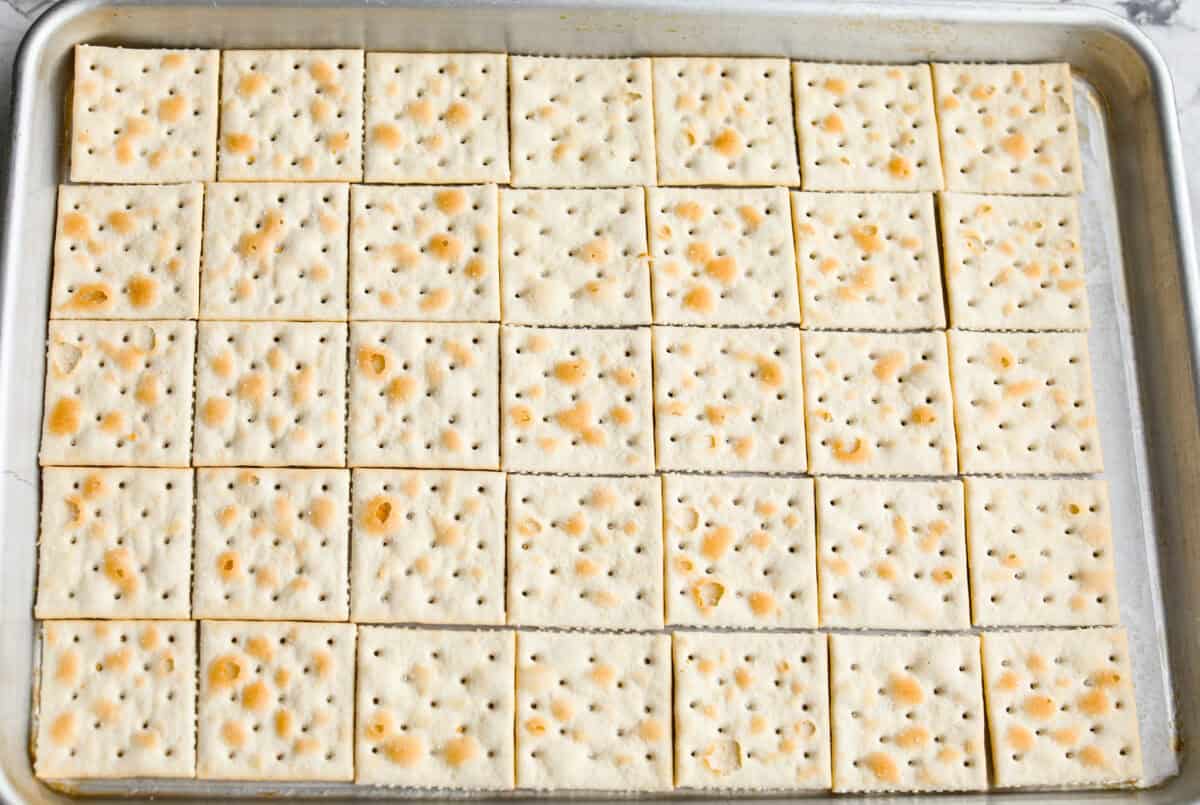 Saltine crackers spread evenly on the baking sheet. 