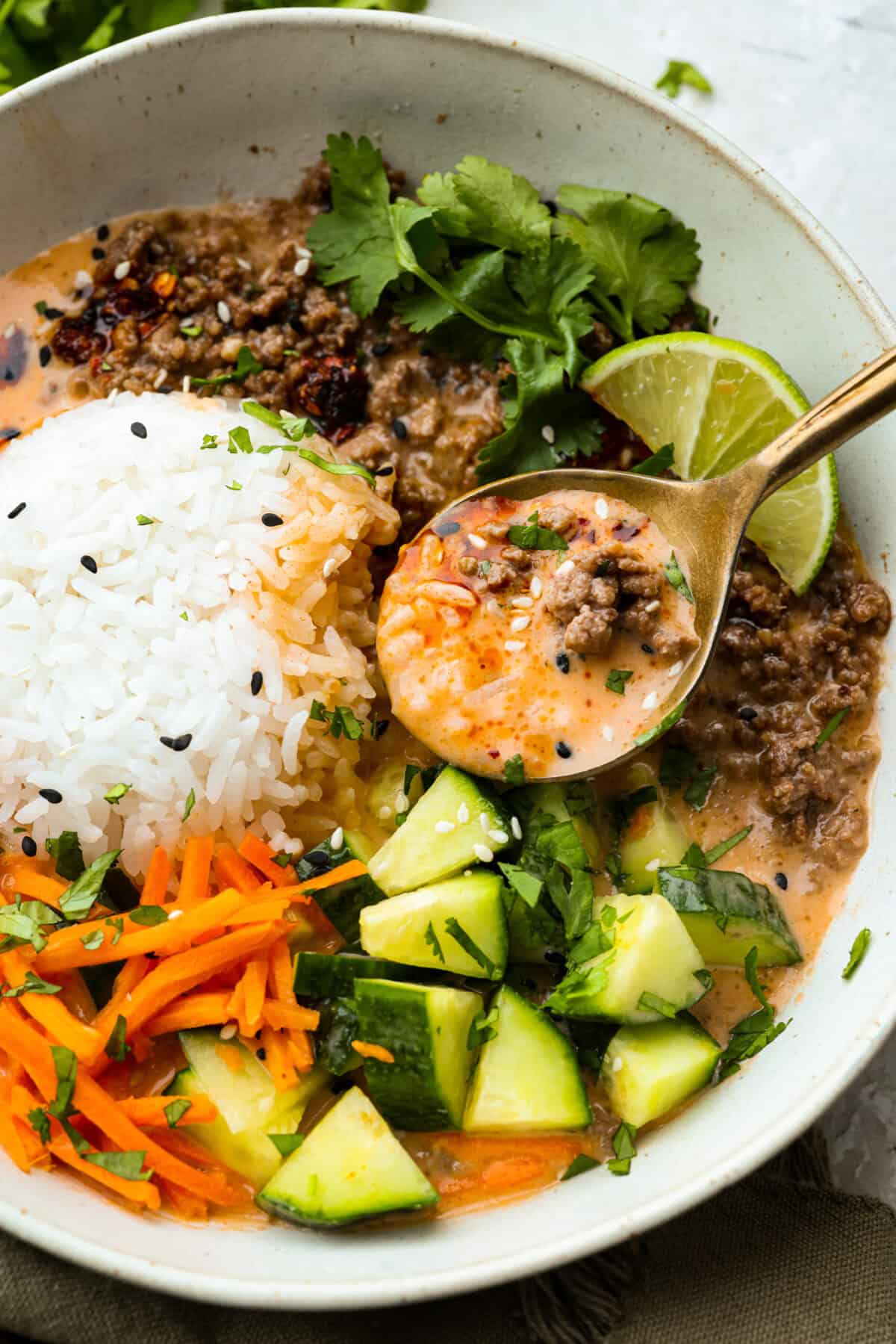 Close up shot of the prepared beef broth bowl with someone lifting a spoonful of it out. 