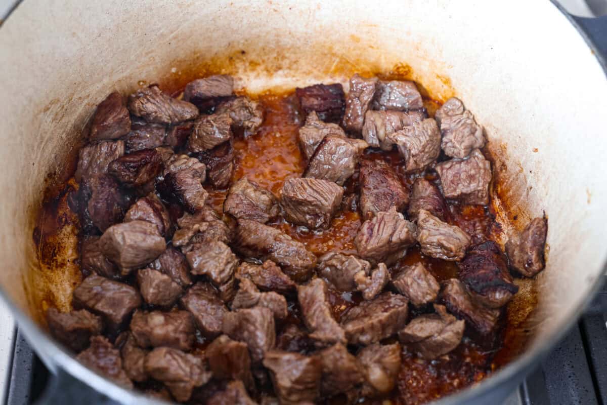 Cubed beef browning in the bottom of the dutch oven. 