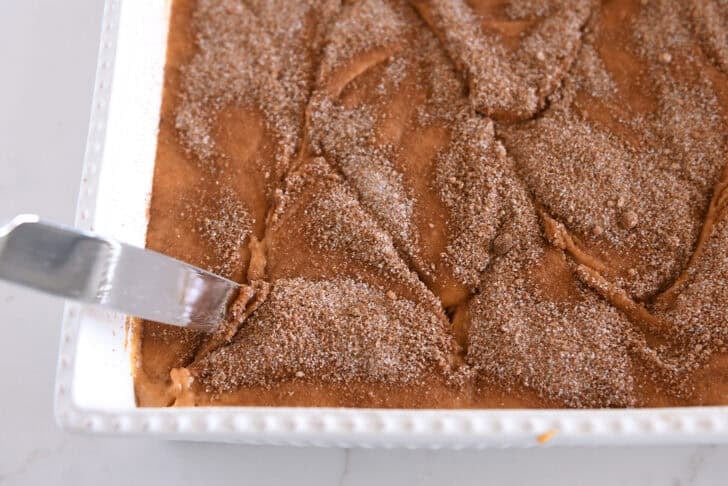 Running swirls through cinnamon swirled pumpkin cake in white 9X13-inch pan.