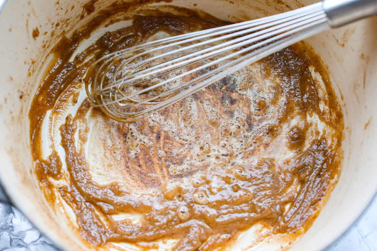 Someone creating a roux with butter, flour, and the browned its left behind by browning the beef. 