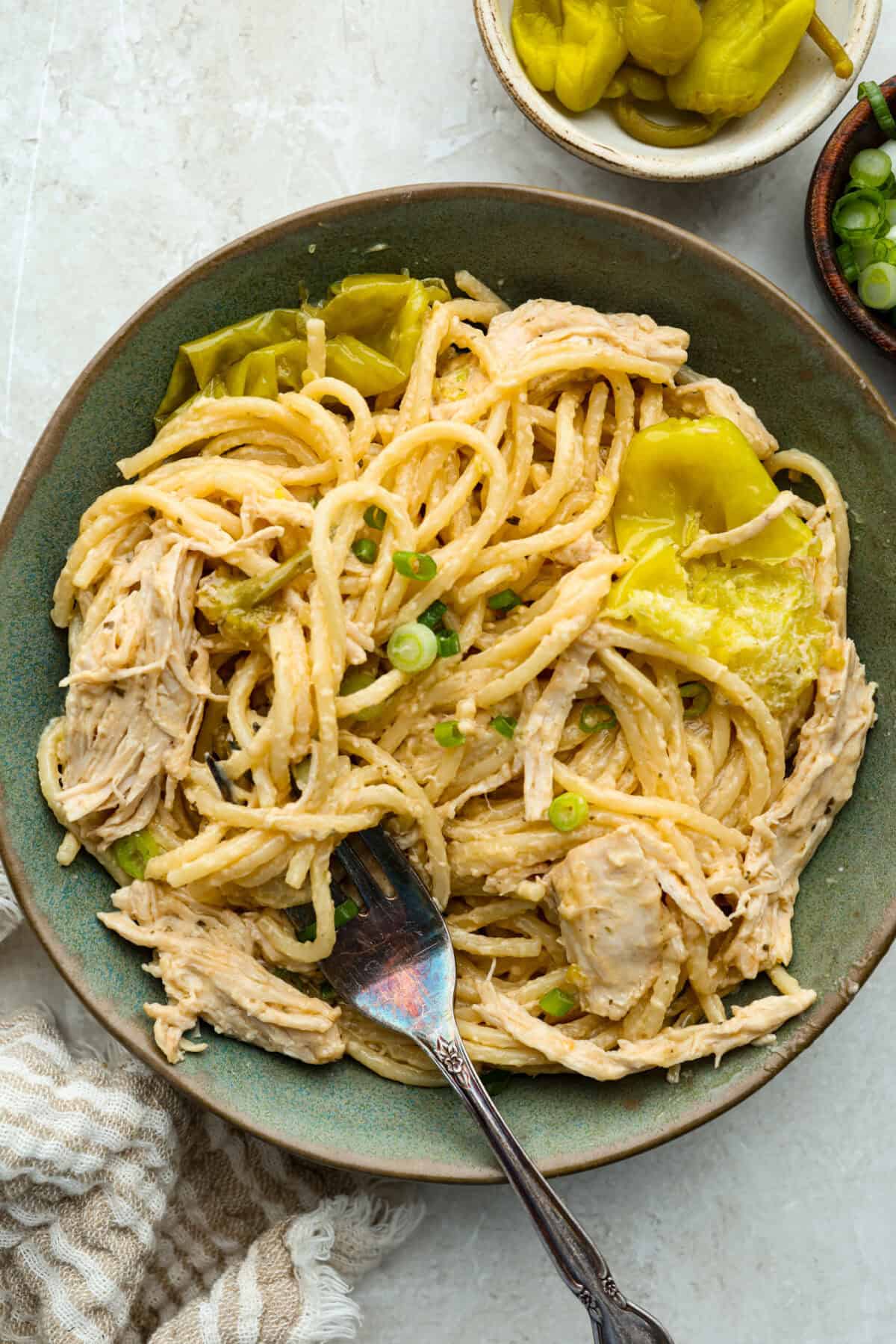 Serving portion of mississippi chicken spaghetti in a bowl with a fork. 