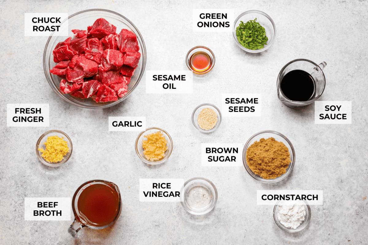 Overhead shot of labeled slow cooker sesame ginger beef ingredients. 