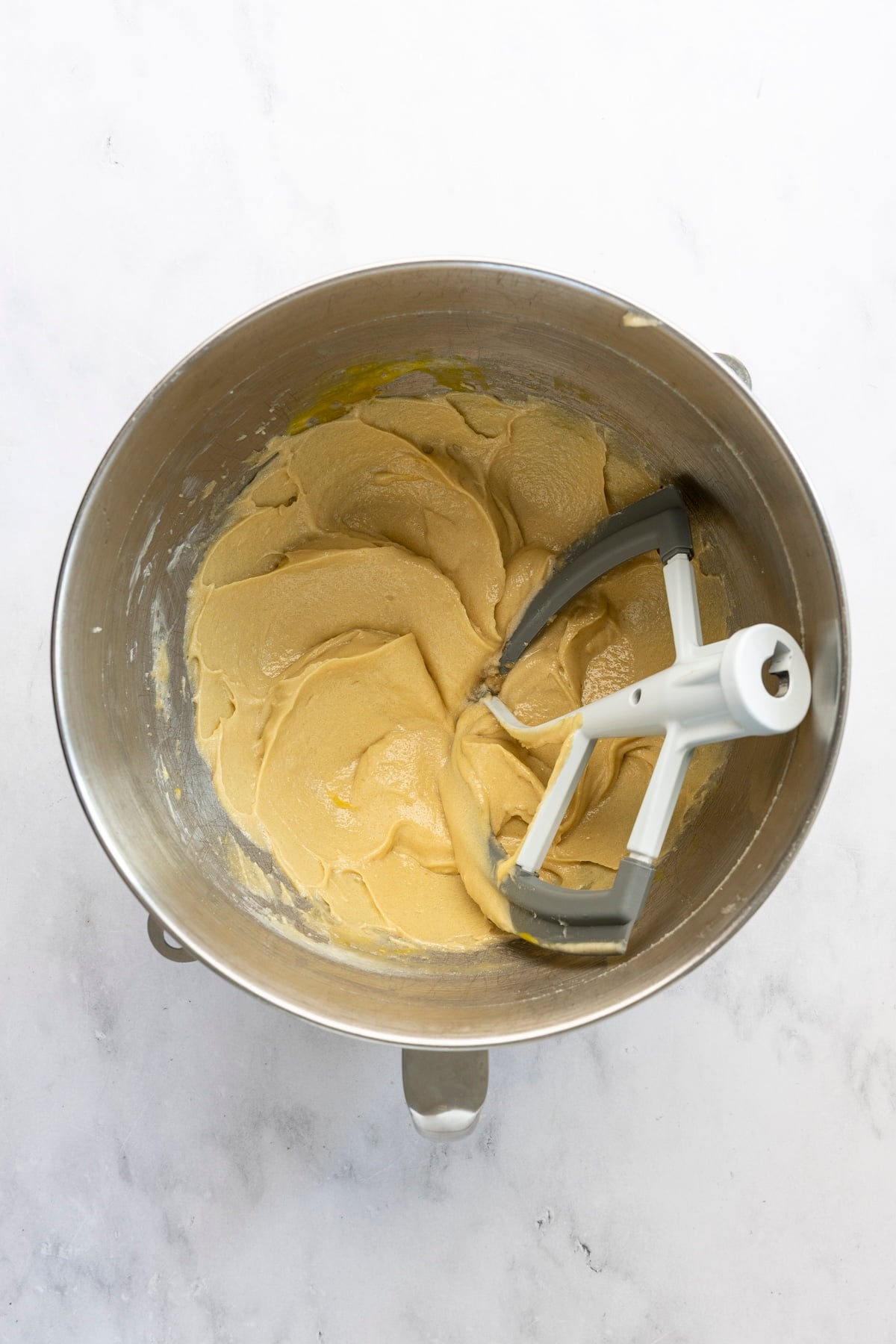 mixing bowl with egg, egg yolk, and vanilla combined with butter/sugar mixture