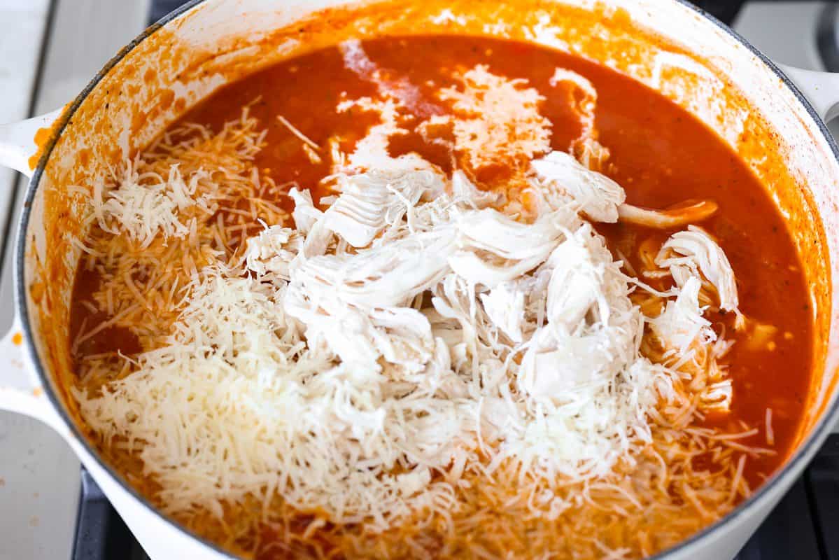 Shredded chicken, heavy cream, and  Parmesan cheese added to the pot. 