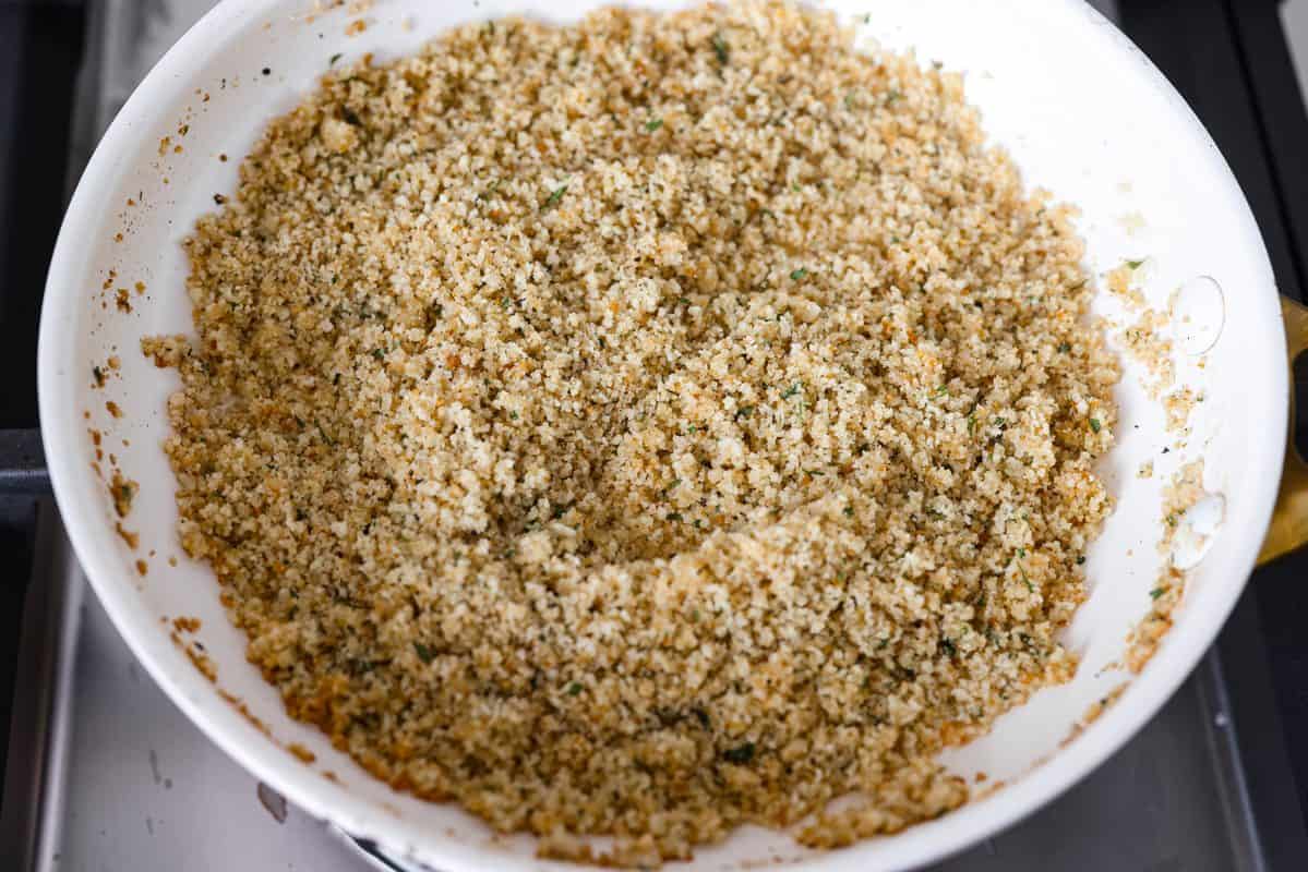 Breadcrumbs added to the melted butter in the pan.
