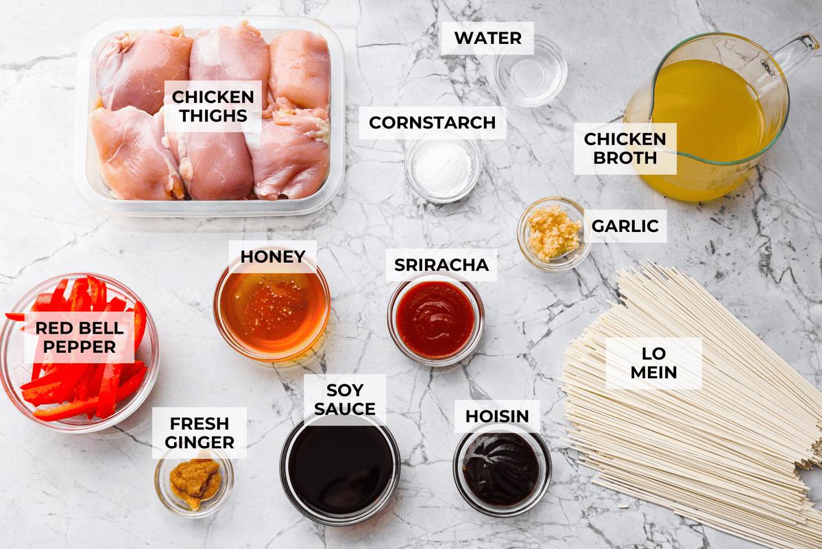 Overhead shot of labeled slow cooker honey garlic chicken noodles ingredients. 