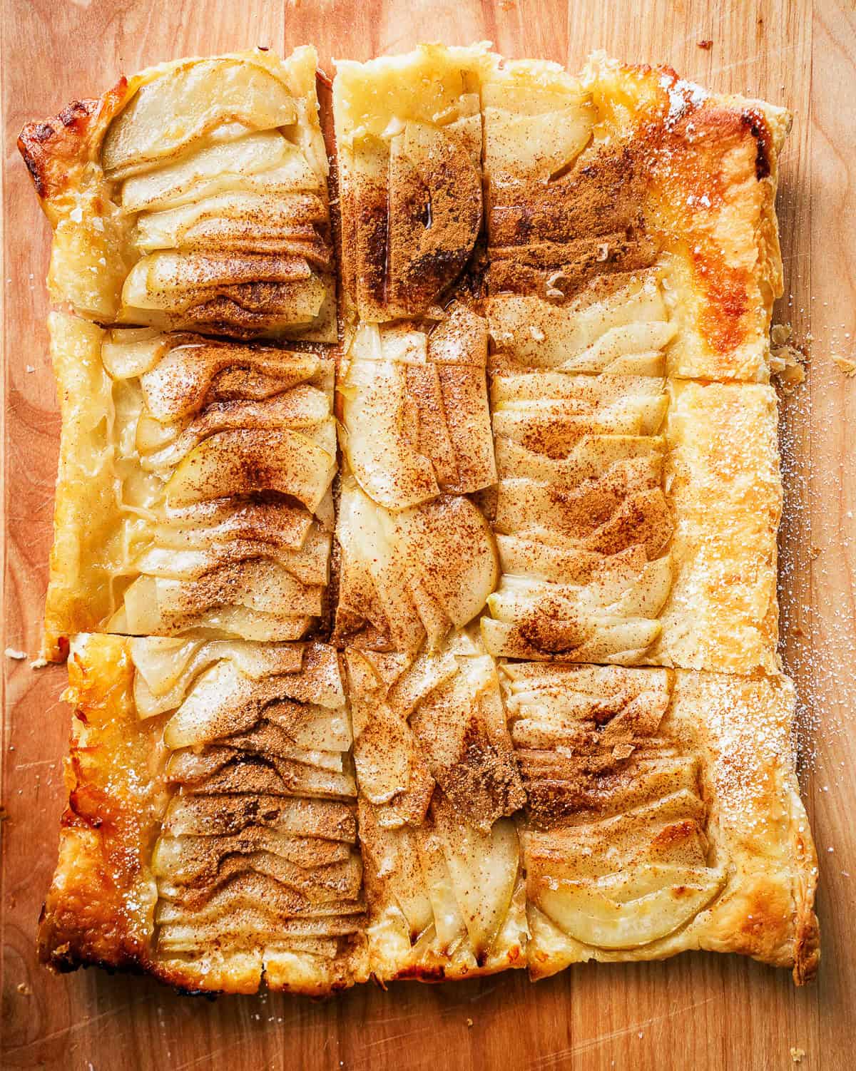 a pear tart on a wood cutting board