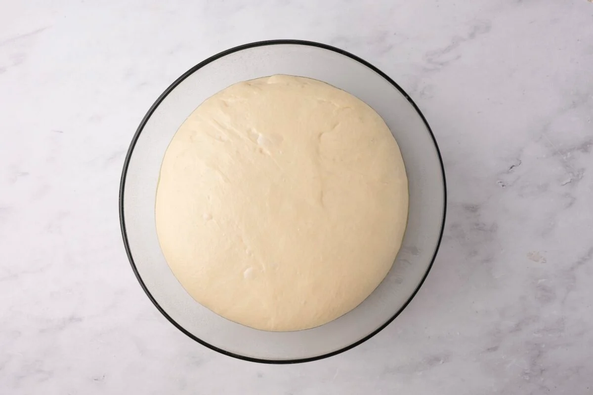 glass bowl with English muffin dough after rising