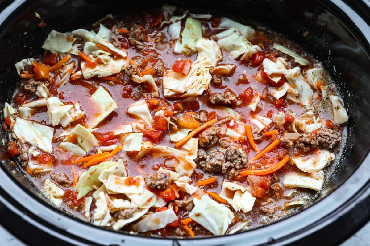 Cabbage roll soup ingredients added to the crockpot. 